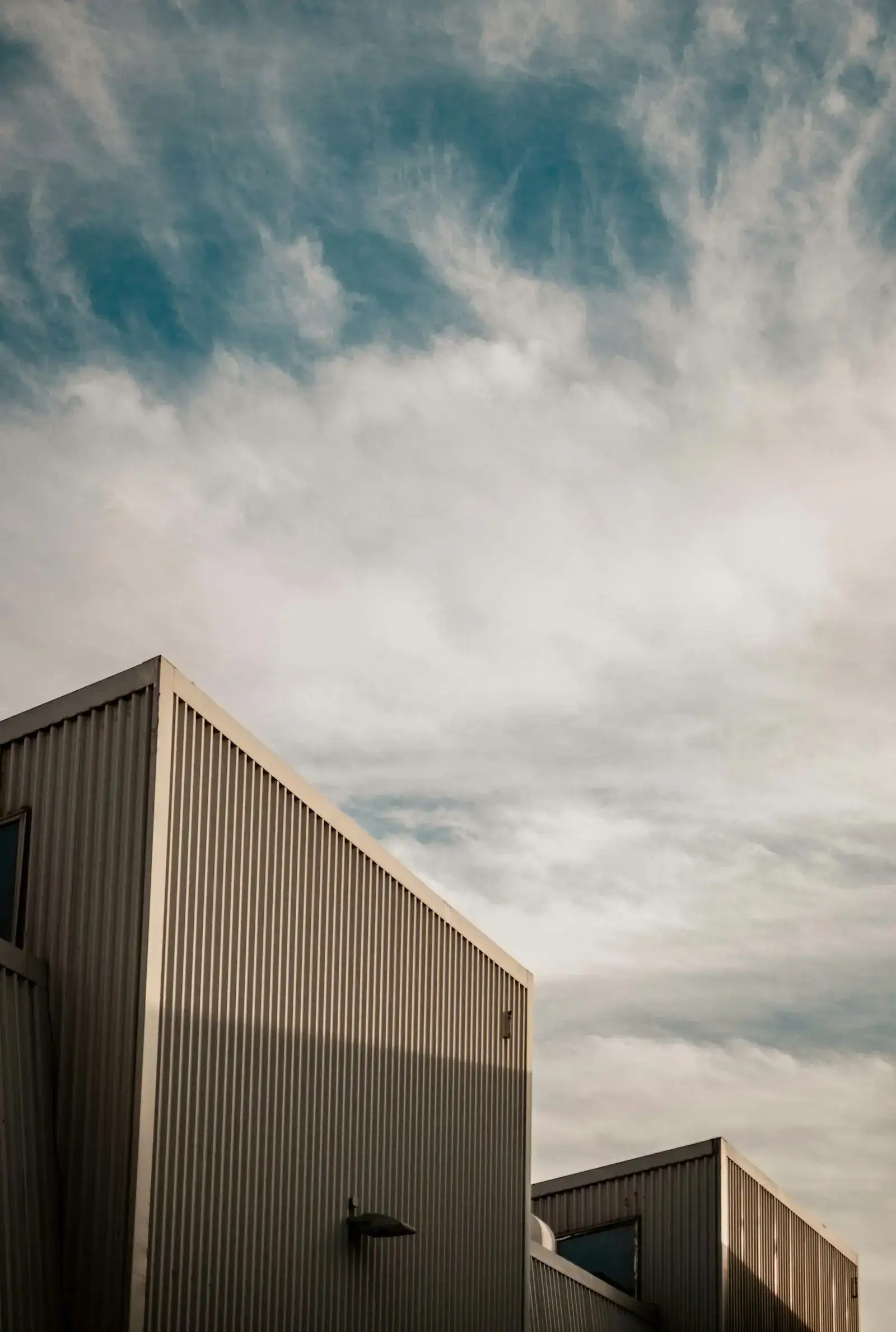 Metal-clad commercial building against a cloudy sky